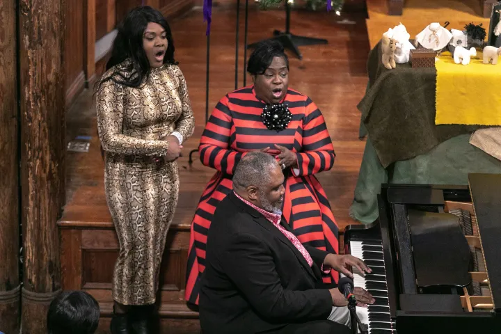 Ladies singing, man playing the piano